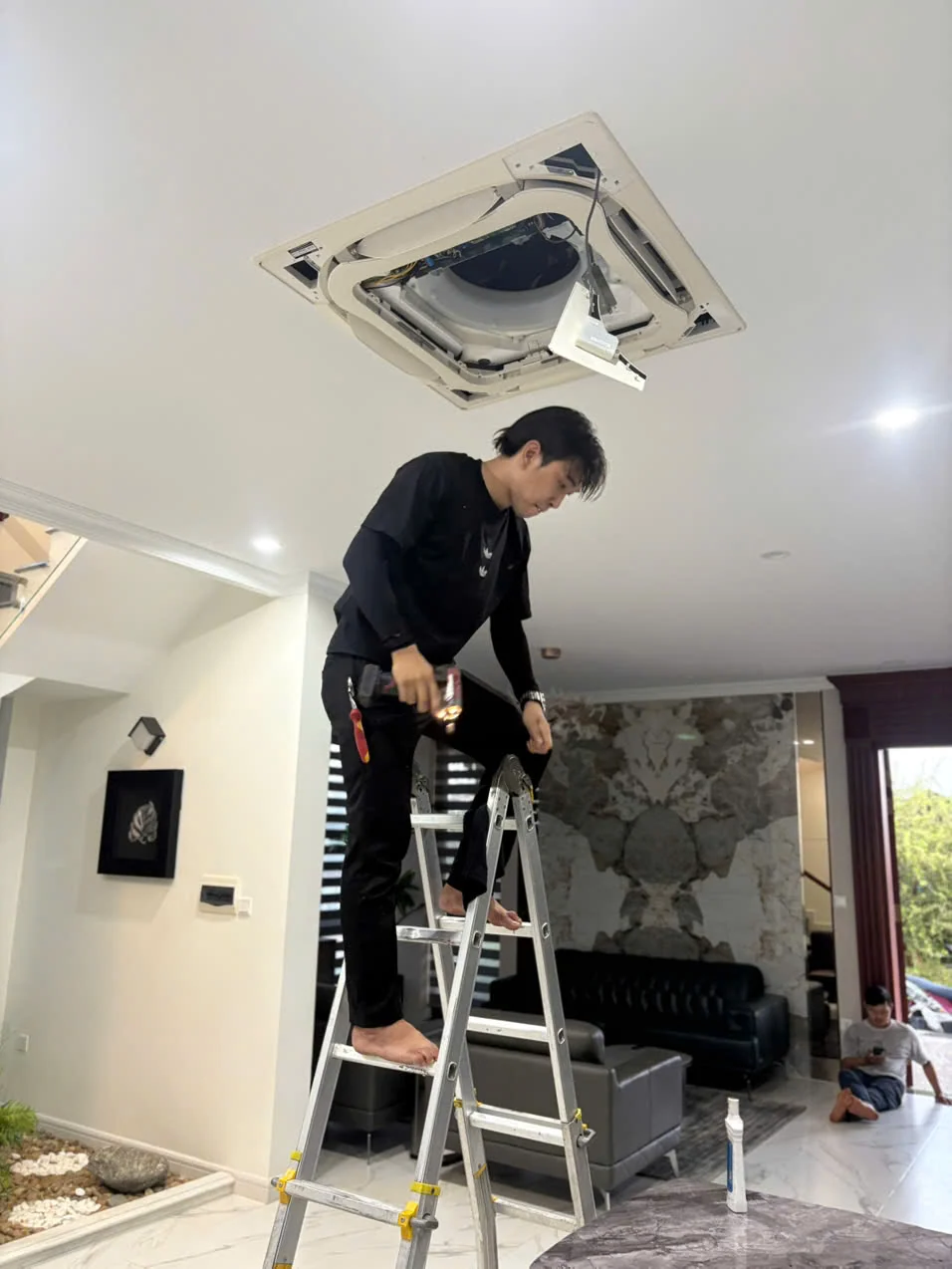 Kỹ thuật viên kiểm tra máy lạnh tại nhà khách hàng